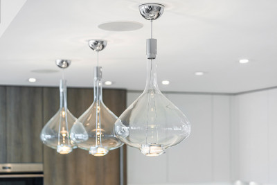 Amrit custom pedant lighting over luxuirous waterfall island in kitchen