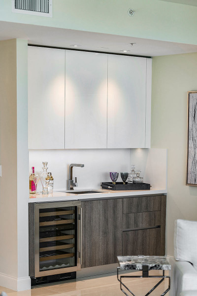 Mini wet bar adjacent to living room with chilled wine storage and custom European cabinetry